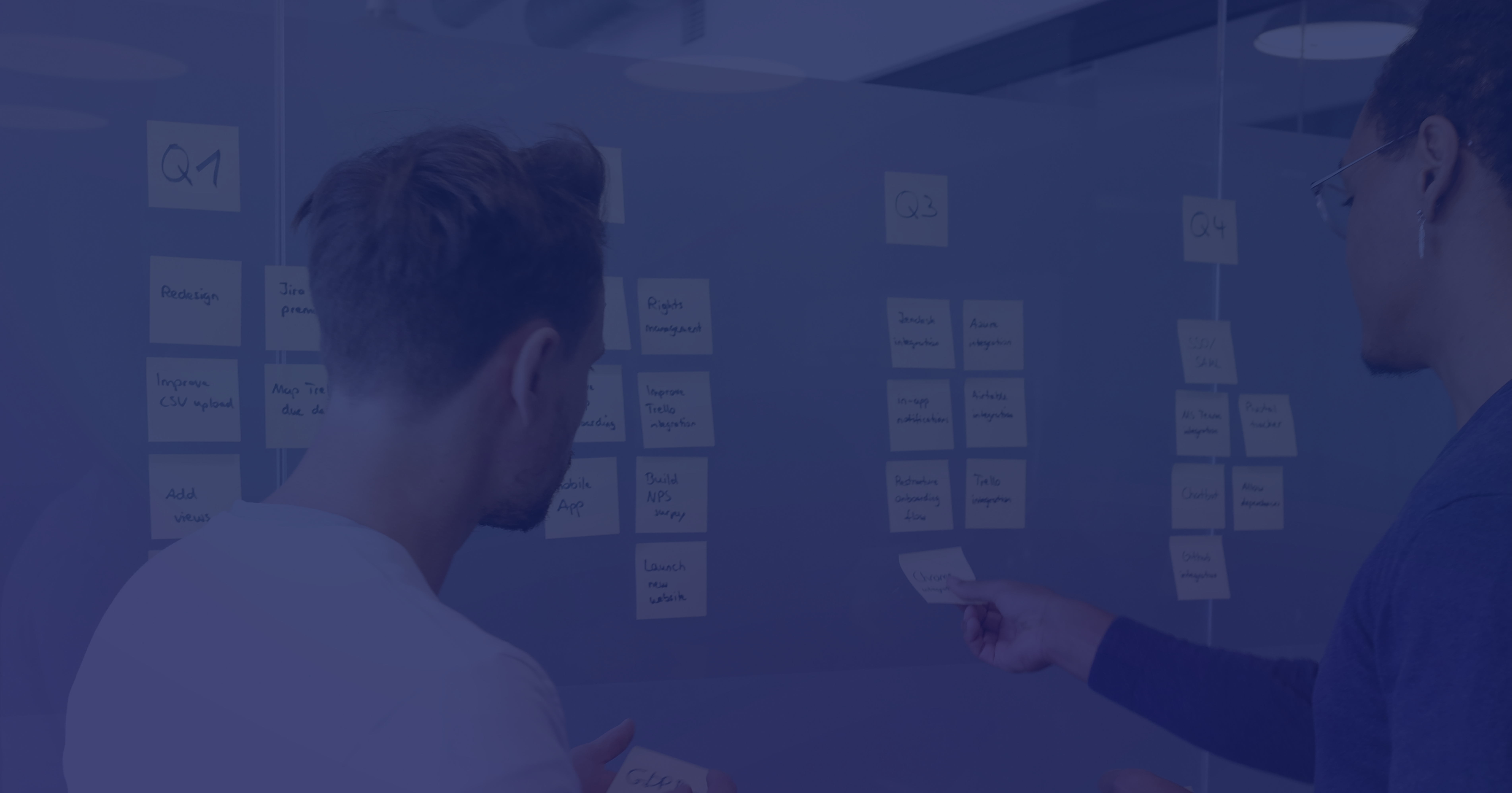 Person organizing sticky notes or cards on wall for project planning, with purple overlay filter