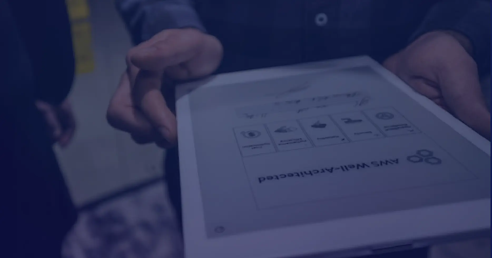 Close-up of hands holding a tablet showing AWS Well-Architected Review components, emphasizing secure and scalable cloud architecture